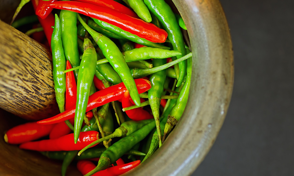Thai green and red chillies in a mortar and pestle