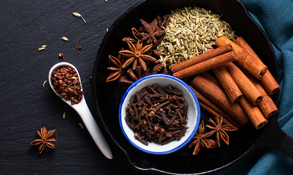 Star anise, fennel, cinnamon sticks and cloves on a platter