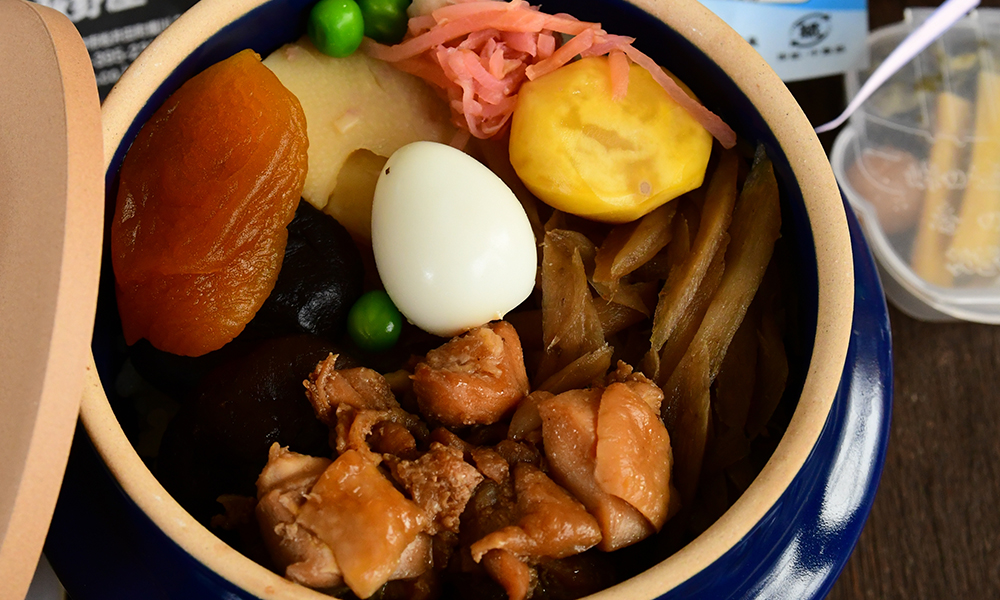 Oval shaped bento box with rice and various fillings