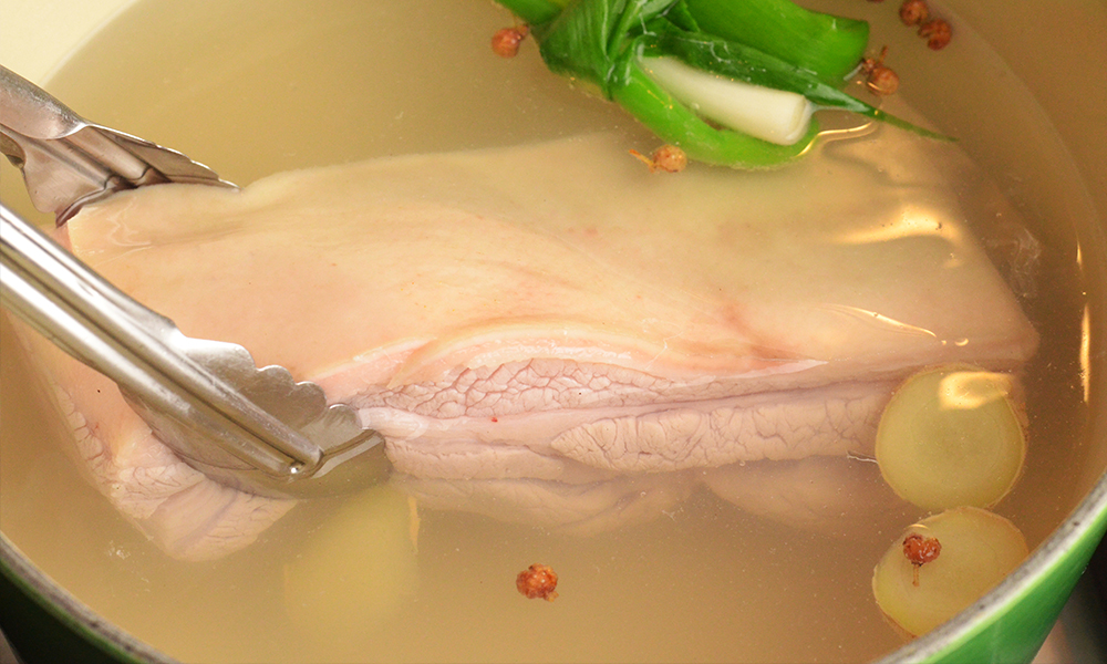 Boiling pork belly in pot of water