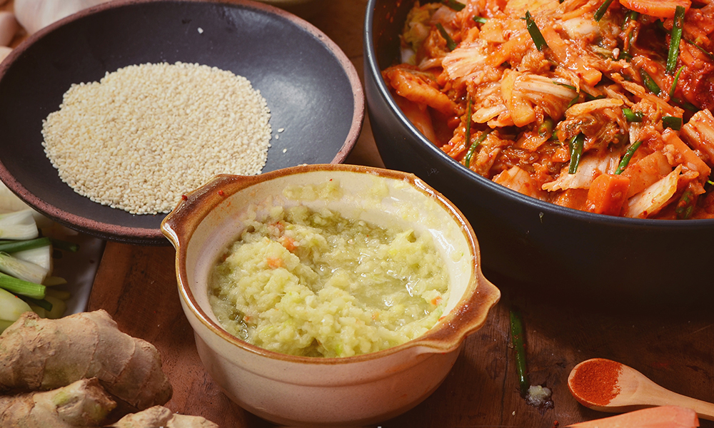 Minced ginger next to bowl of kimchi